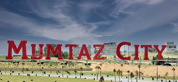 Mumtaz City entrance signage with the development and road network beyond